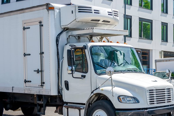 A box truck with a reefer unit attached over the cab. 