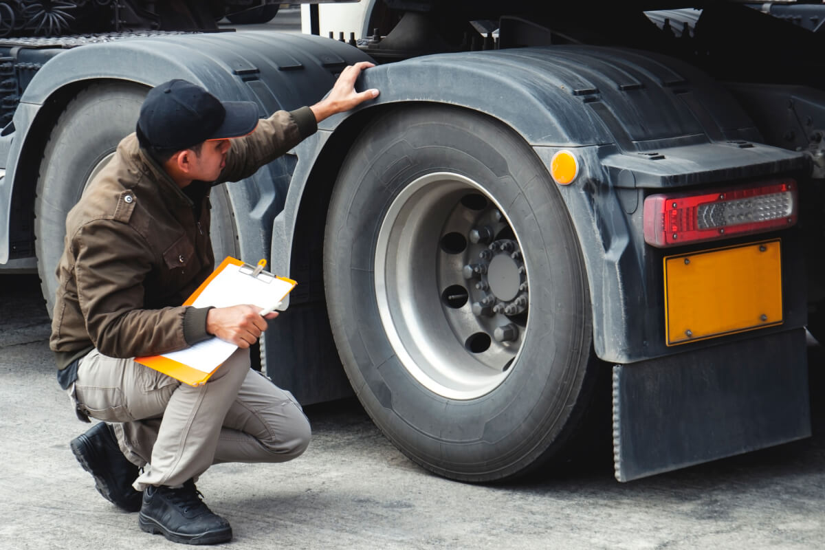 image of fleet manager inspecting a truck tire