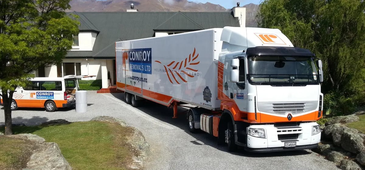 Conroy Removals truck and van parked on a gravel driveway beside a house