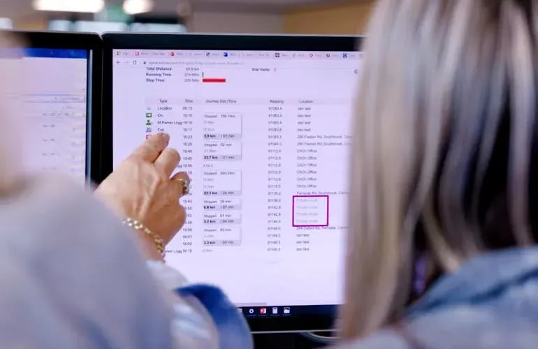 Person pointing at a trip log on a monitor, with several location entries highlighted in a box
