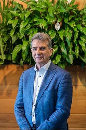 Selwyn Pellett of Coretex standing in front of a green plant wall