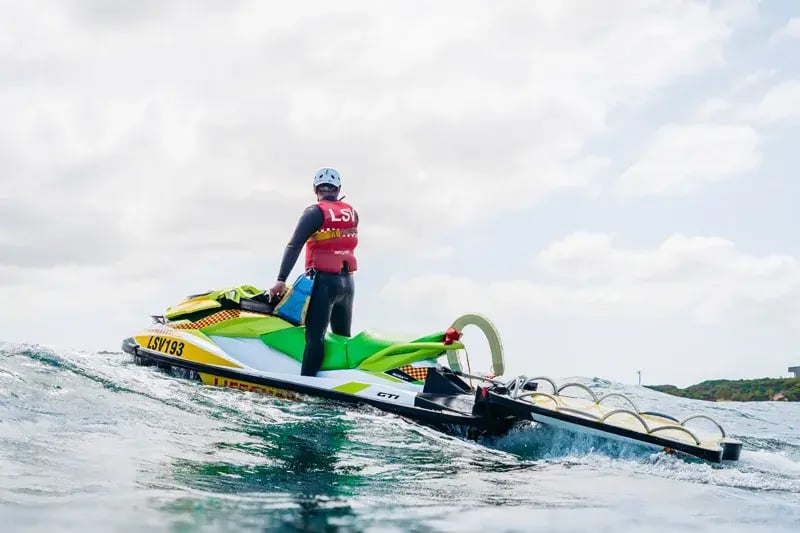 Life Saving Victoria lifesaver standing on a rescue jet ski with a rescue sled, out on the water