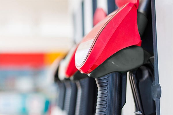 Close-up of red fuel pump nozzles at a service station