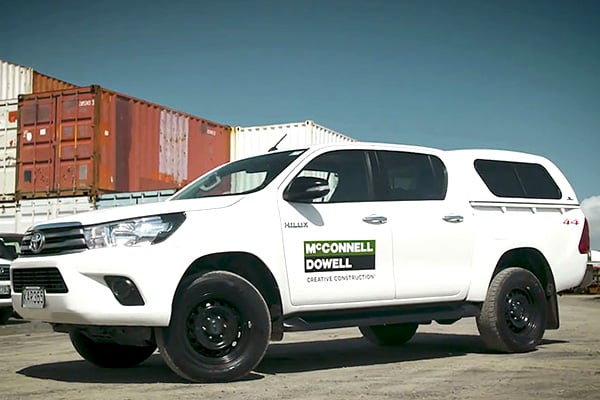 White McConnell Dowell Toyota Hilux ute parked in front of shipping containers