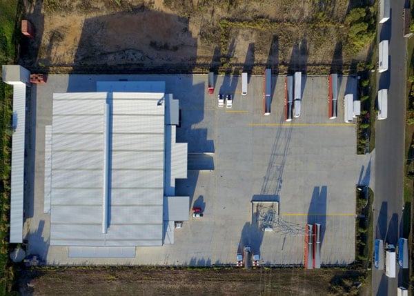 Aerial view of a depot with trucks and trailers parked around a large warehouse