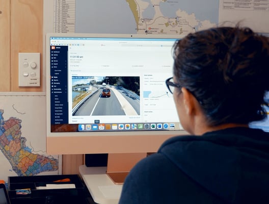 An EROAD team member reviewing fleet footage at a desk