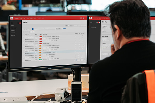 A fleet manager reviewing MyEROAD Fleet Maintenance screens on desktop monitors