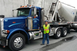 J A Jack and Sons driver standing next to his blue mixer truck