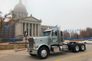 light blue Recoil Oilfield Services truck in front of capital building