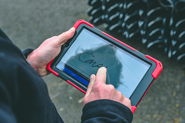 Customer signing on tablet confirming proof of delivery