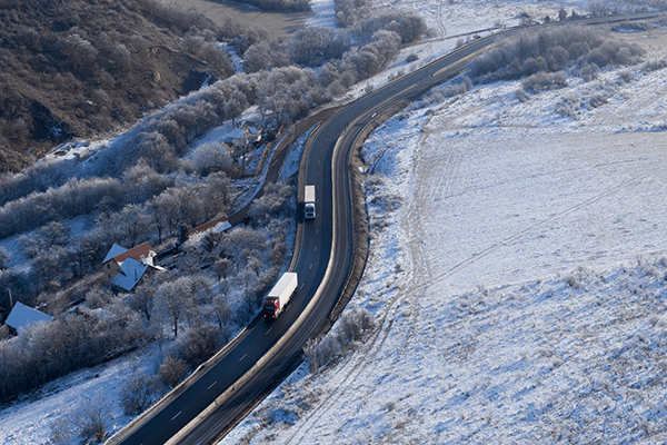 winding road with trucks in a frozen landscape